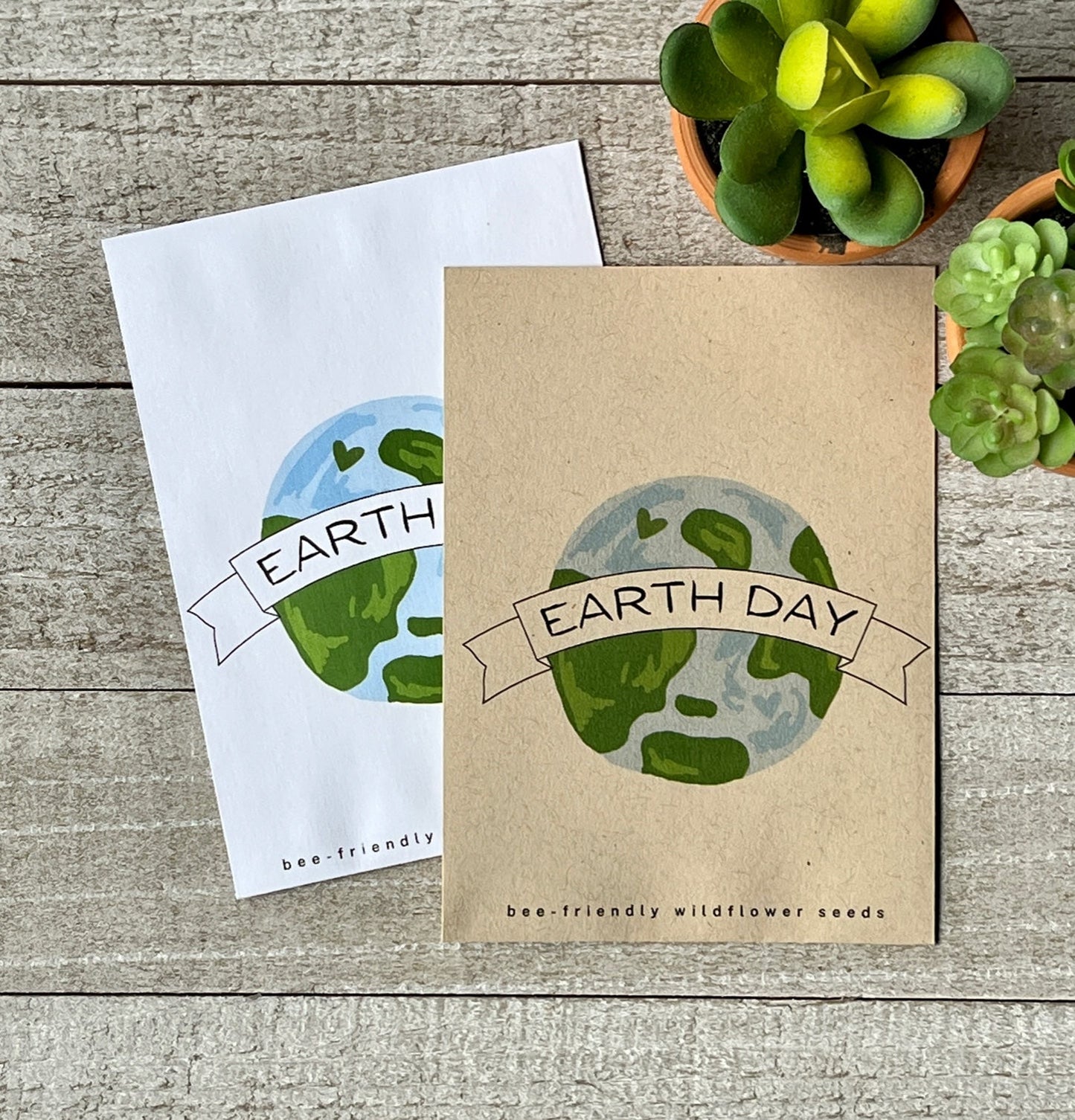 A white and a brown seed packet with an illustration of the earth and the words, Earth Day.