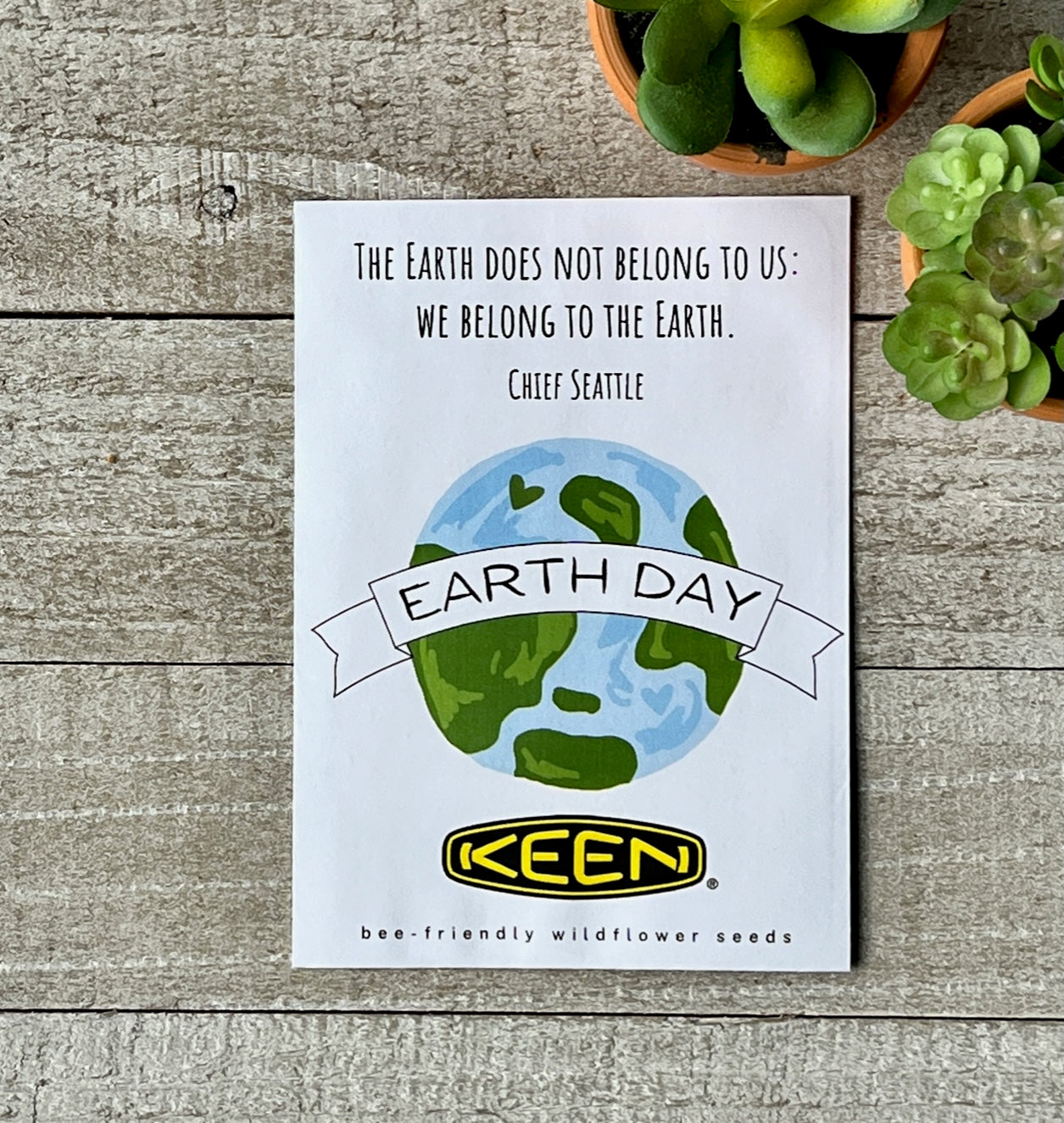 A white seed packet with an illustration of the earth and a company logo and text.