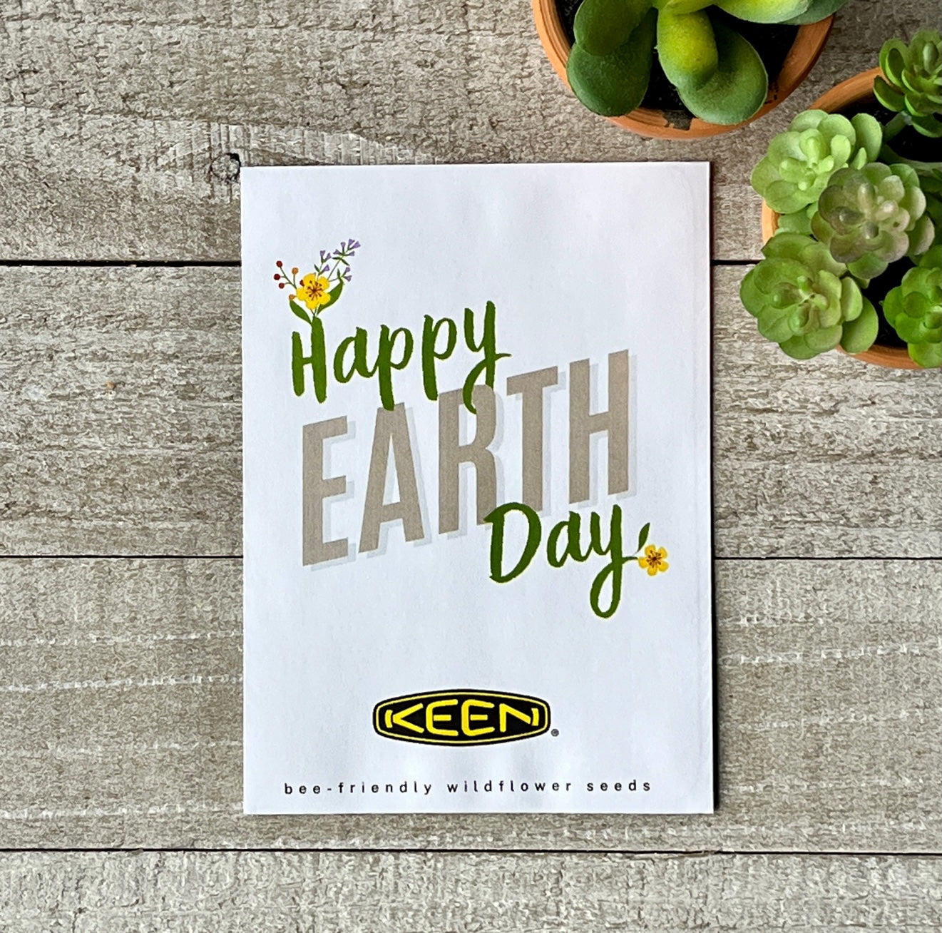 A white seed packet that says "Happy Earth Day," and a corporate logo.