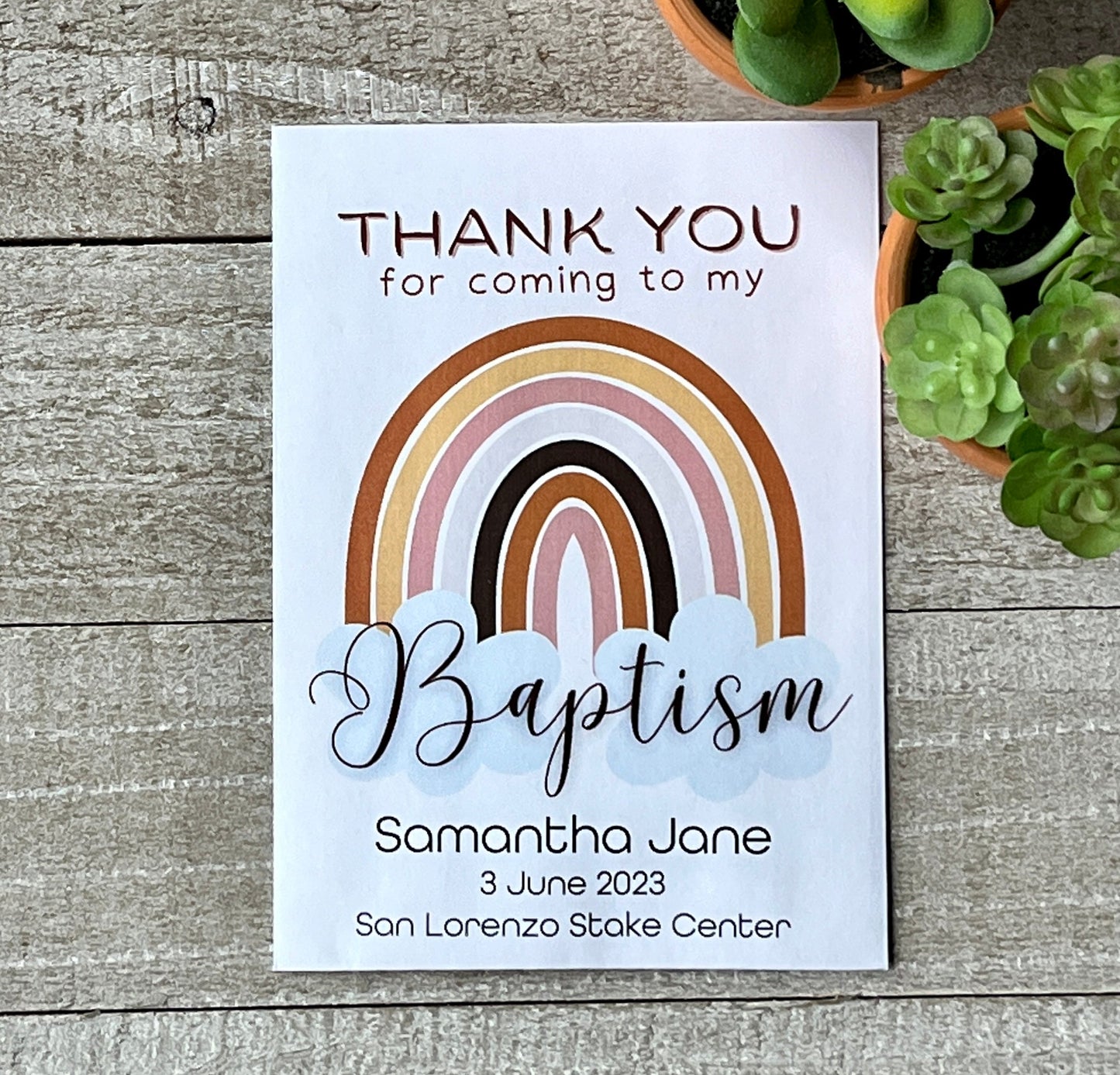 One white baptism seed favor with a rainbow and the words, thank you for coming to my baptism.