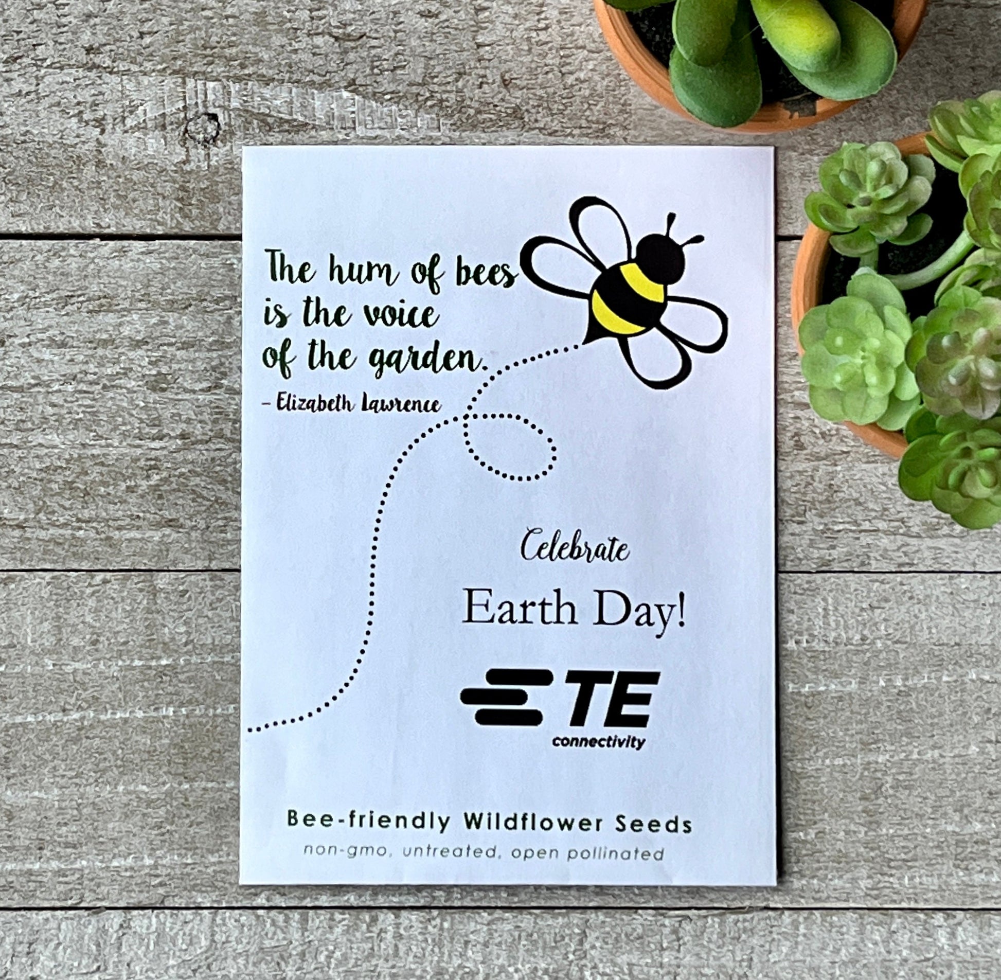 A white seed packet with a drawing of a buzzing bee and a quote about bees.